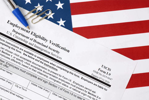 Form I-9 Sitting on the American Flag with a Pen on Top