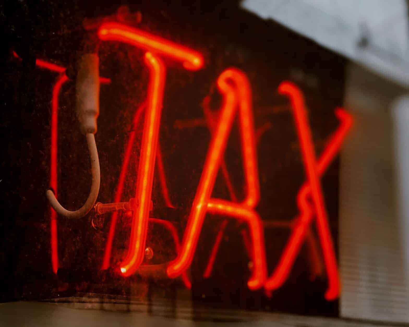 Lit up sign that says Tax